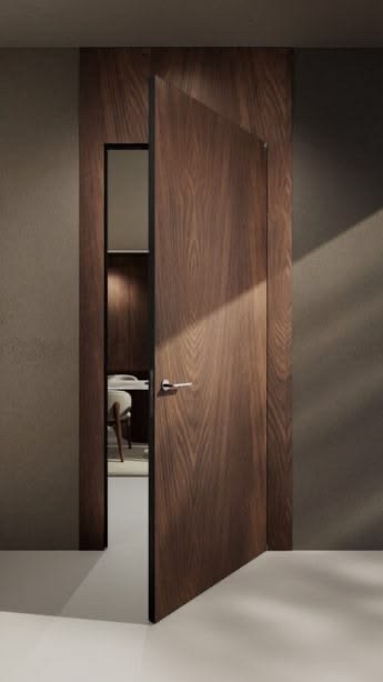 Porta filomuro in noce aperta su uno studio, con telaio nascosto nella parete